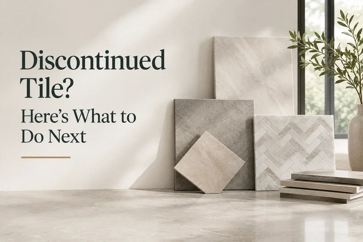 Assorted tile samples are arranged on a light floor beside a potted plant, with text reading, “Discontinued Tile? Here’s What to Do Next” on the wall.
